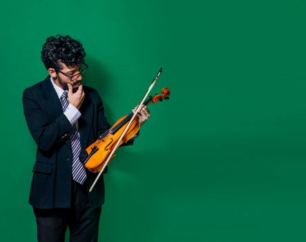 pensive man looking at the violin, Portrait of male violinist looking at his violin while thinking