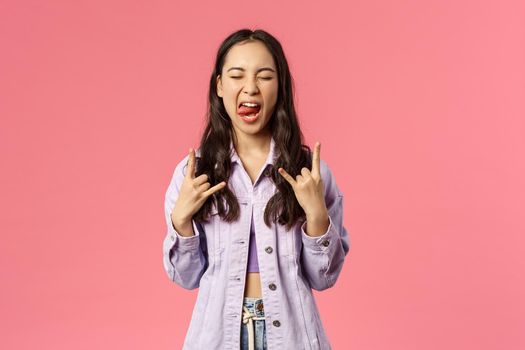 Portrait of joyful good-looking stylish girl enjoying awesome music concert, having fun carefree show tongue and rock-n-roll signs, say heavy metal close eyes and move head rythm awesome song.