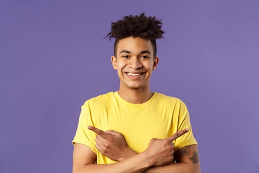 Close-up portrait of pleased, good-looking hispanic man promoting two products, showing both ways good, give variants, pointing fingers left and right, smiling recommend check out all.