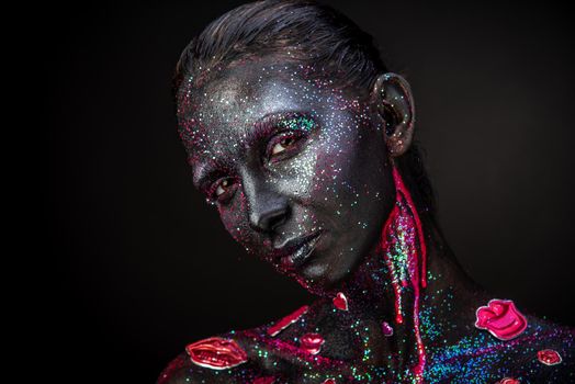 Mystical woman makeup with sparkles and luminous elements on a dark background