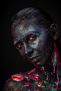 Mystical woman makeup with sparkles and luminous elements on a dark background
