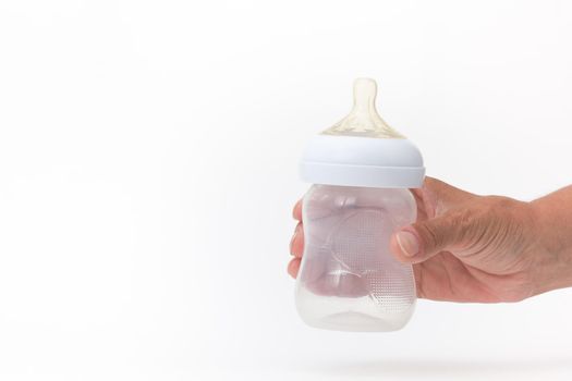 Isolated empty bottle feeding in cropped woman hand on white background