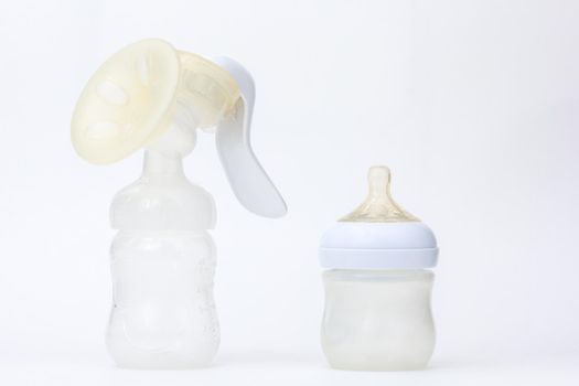 Isolated baby empty bottle feeding and manual breast pump on white background