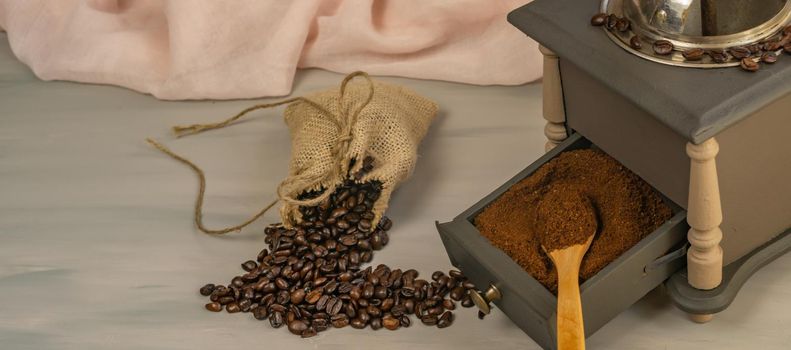 coffee beans and ground coffee with coffee grinder and flowers