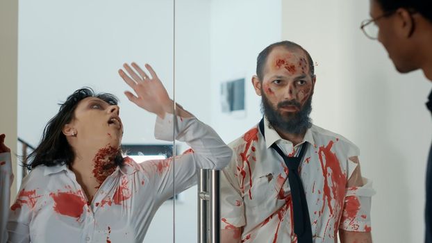 Mindless creepy monsters with deep scars trying to enter inside office workspace. Apocalyptic spooky brain-eating monsters looking for new victims while rubbing their faces on glass door.