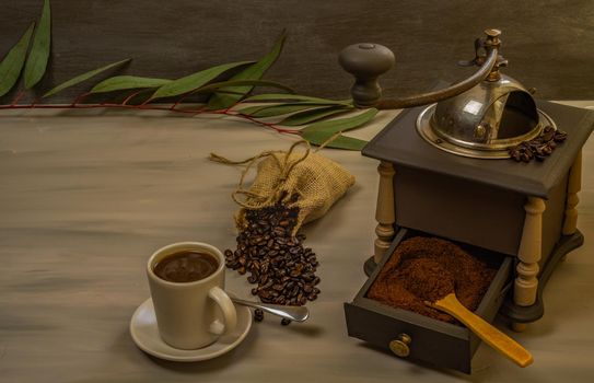 coffee beans and ground coffee with coffee grinder and flowers