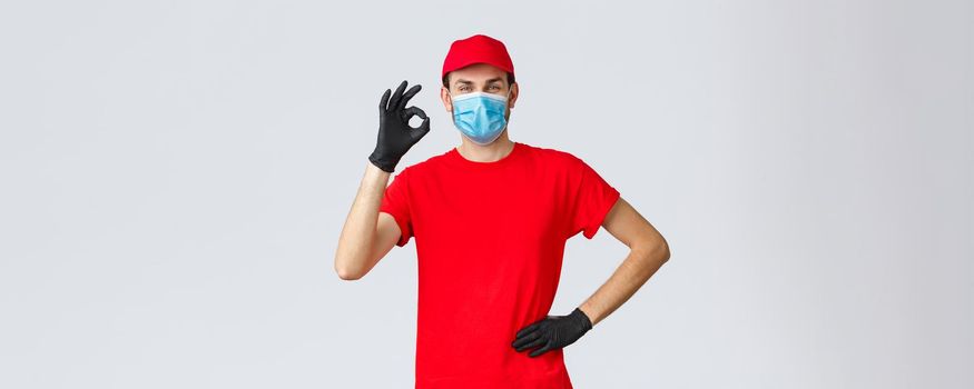 Covid-19, self-quarantine, shopping concept. Courier have no problem delivering your packages, food from shops to house during coronavirus, wear face mask and gloves, delivery guy show ok.