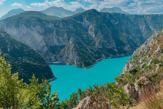 The concept of eco-tourism and active recreation. National Park. Mountain Emerald lake in the wooded mountains. Sunny day in autumn.