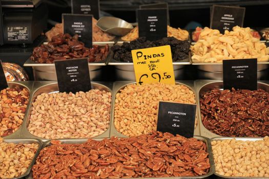 Fresh nuts on a market stall (text on tags: names and prices of various nuts in Dutch,pecan nuts, peanuts, pistacho, para and cashew)