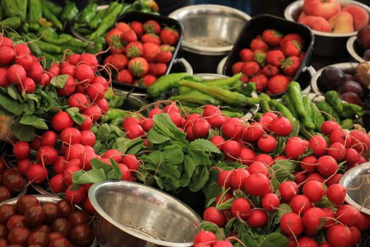 Fresh red radish on a market stall, Radish and other vegetables displayed in small metal bowls