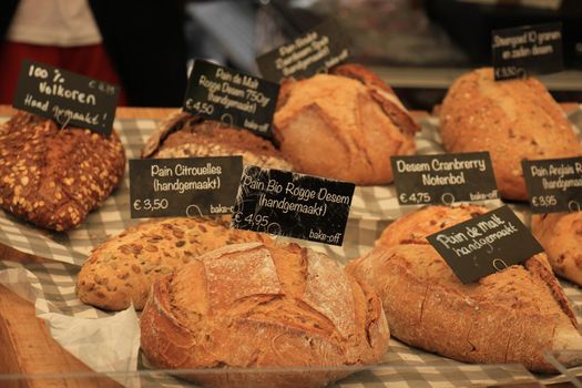 Luxury artisanal bread at a market (text on tags: product and price information in Dutch)