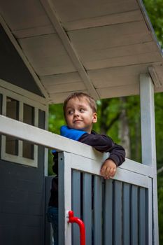 A child is playing on the playground in a children's house. Presents himself as the owner of the house. Portrait of a child. childhood, games, joy, emotions.