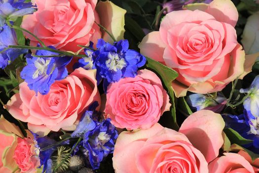 Pink roses and blue larkspur in a floral wedding decoration