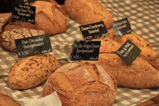 Luxury artisanal bread at a market (text on tags: product and price information in Dutch)