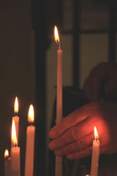 Man lit a candle in a roman catholic church