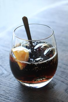 Glass of cola with ice cubes and slices of lemon