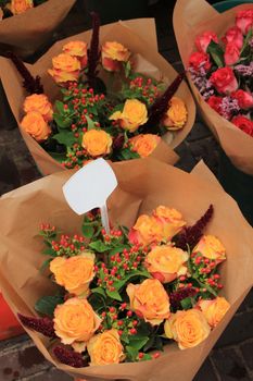 Bouquets with roses at a market, wrapped in paper