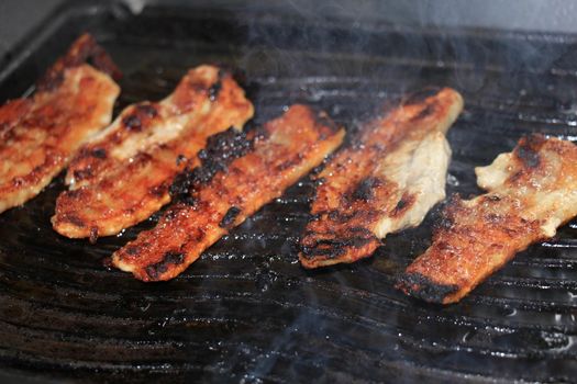 Small pork steaks on a cast iron grill