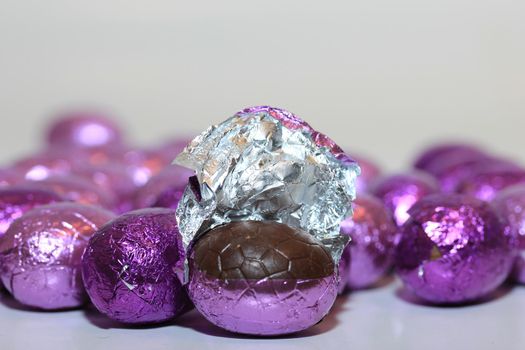 colorful wrapped chocolate easter eggs in close-up, macro