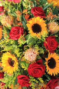 Sunflowers and big red roses in a wedding arrangement