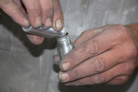 Man preparing filler in a vehicle repair shop