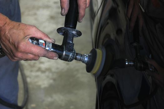 Man polishing a car after a car repair job