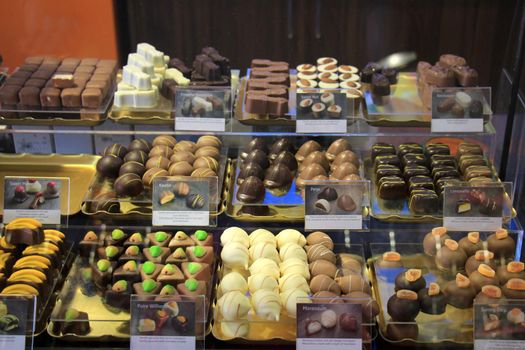 Luxurious Chocolates on display in a confectioner's shop (tags: price and product information in Dutch)