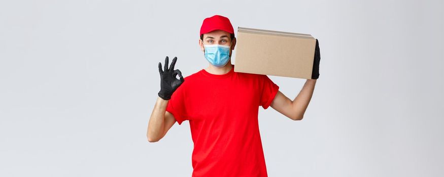 Packages and parcels delivery, covid-19 quarantine delivery, transfer orders. Courier service of express delivery, hold box on shoulder make okay sign, no problem, guarantee safe buying and shipping.