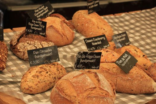 Luxury artisanal bread at a market (text on tags: product and price information in Dutch)