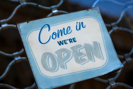 Close up of an open sign on an iron curtain