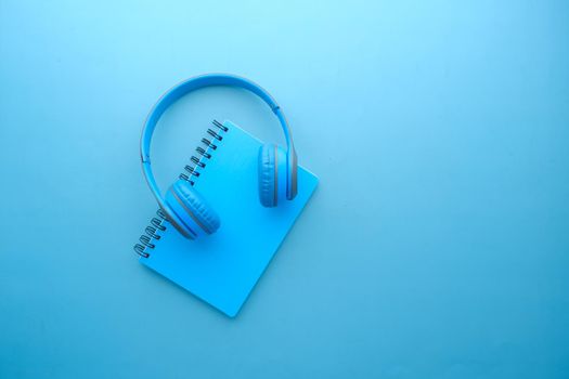 Audio book concept. Headphones and notepad on table .