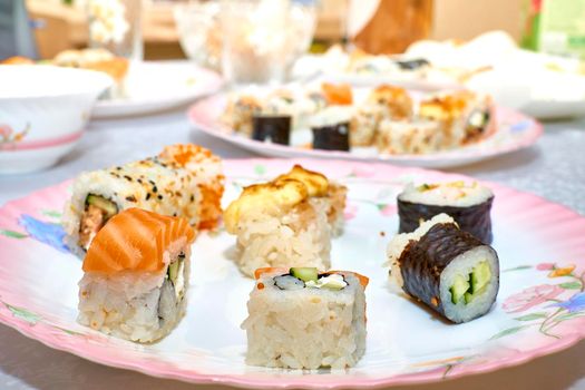 a Japanese dish consisting of small balls or rolls of vinegar-flavored cold cooked rice served with a garnish of raw fish, vegetables, or egg.