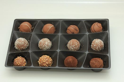 Various chocolates in a tray, bonbons with different topping and filling