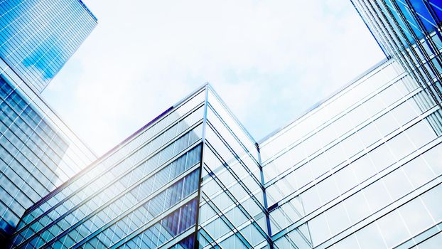 Perfect blue glass high-rise corporate building. Modern office building with glass facade on a clear sky background. Transparent glass wall of office building. 3d Rendering.