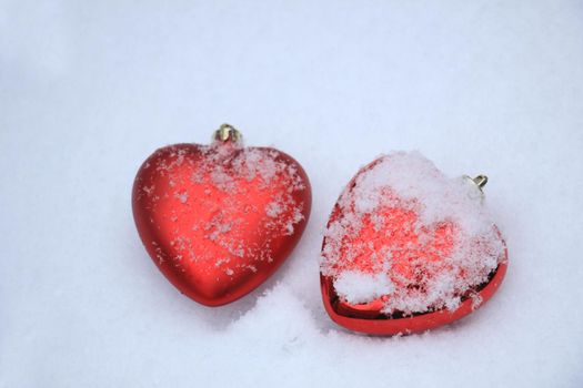 Red heart shaped ornaments in fresh fallen snow