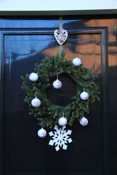 Classic christmas wreath with decorations on a door