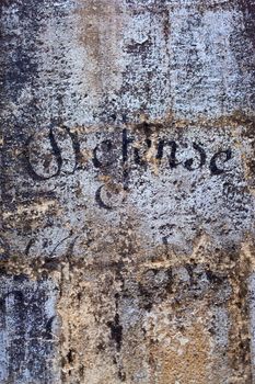 Old painted concrete wall and French forbidden sign