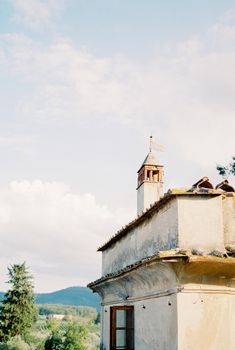 Tower with a flag on the roof of an old villa in the garden. High quality photo