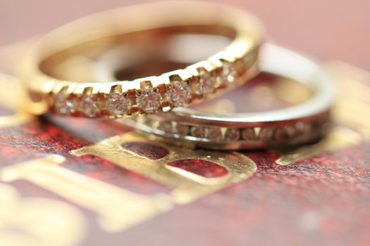 Two diamond wedding bands for a double bride wedding on the cover of the bible