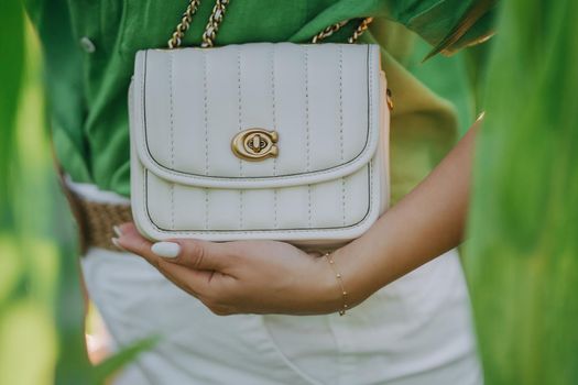 Stylish fashionable woman holding white luxury bag, leather handbag. High quality photo