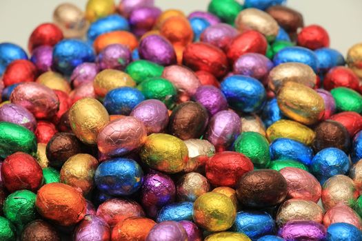 Big pile of colorful wrapped chocolate easter eggs
