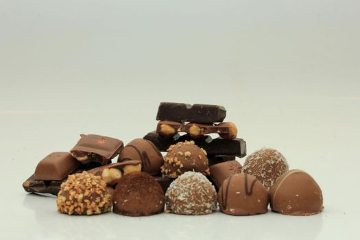 Different sorts of chocolates: bonbons and broken pieces of a chocolate bar