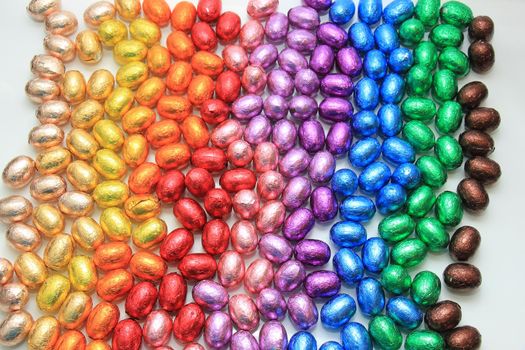 a group of foil wrapped chocolate easter eggs in rainbow colors