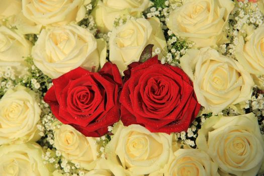 Red roses in a white rose bouquet