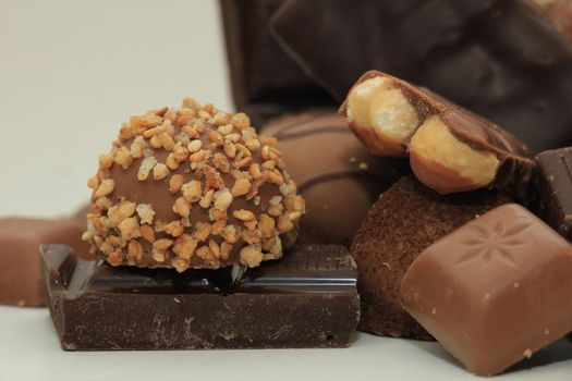 Different sorts of chocolates: bonbons and broken pieces of a chocolate bar