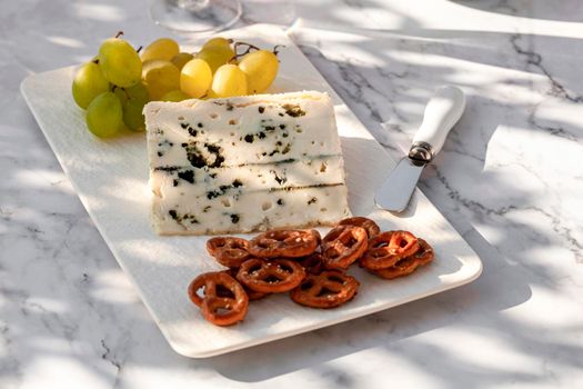 gorgonzola cheese served with green grapes and snacks outdoors, hard light