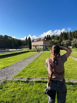 Girl photographs the garden of Villa Milocer. Back view. High quality photo