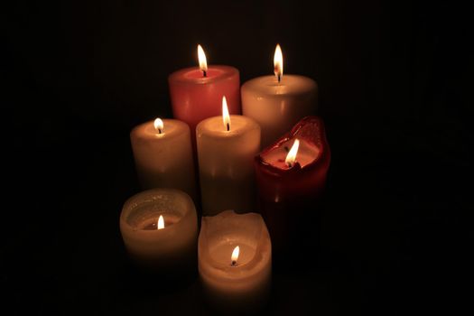 Group of burning candles in different heights and colors