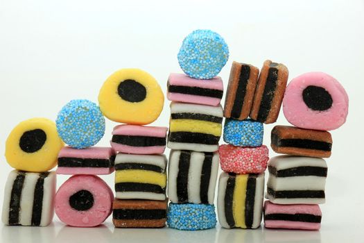 Stacked liquorice all sorts in different shapes, colors and sizes