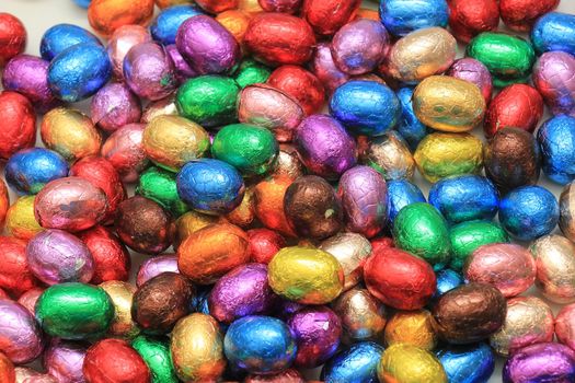 Big pile of colorful wrapped chocolate easter eggs